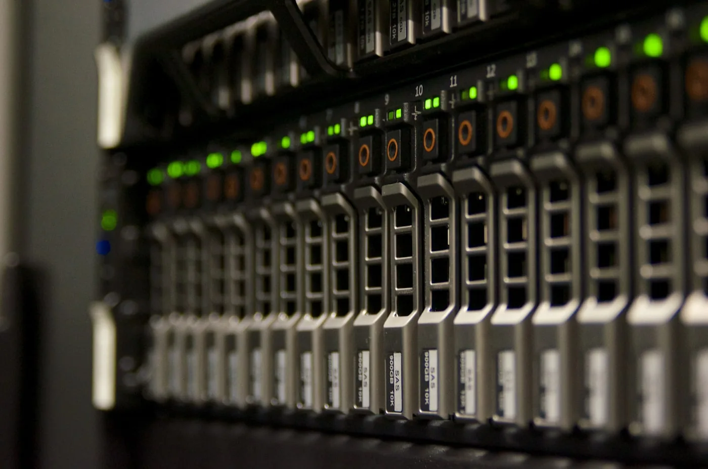 Nahaufnahme der Festplatteneinschübe eines Servers im Rack mit grünen Statusleuchten
