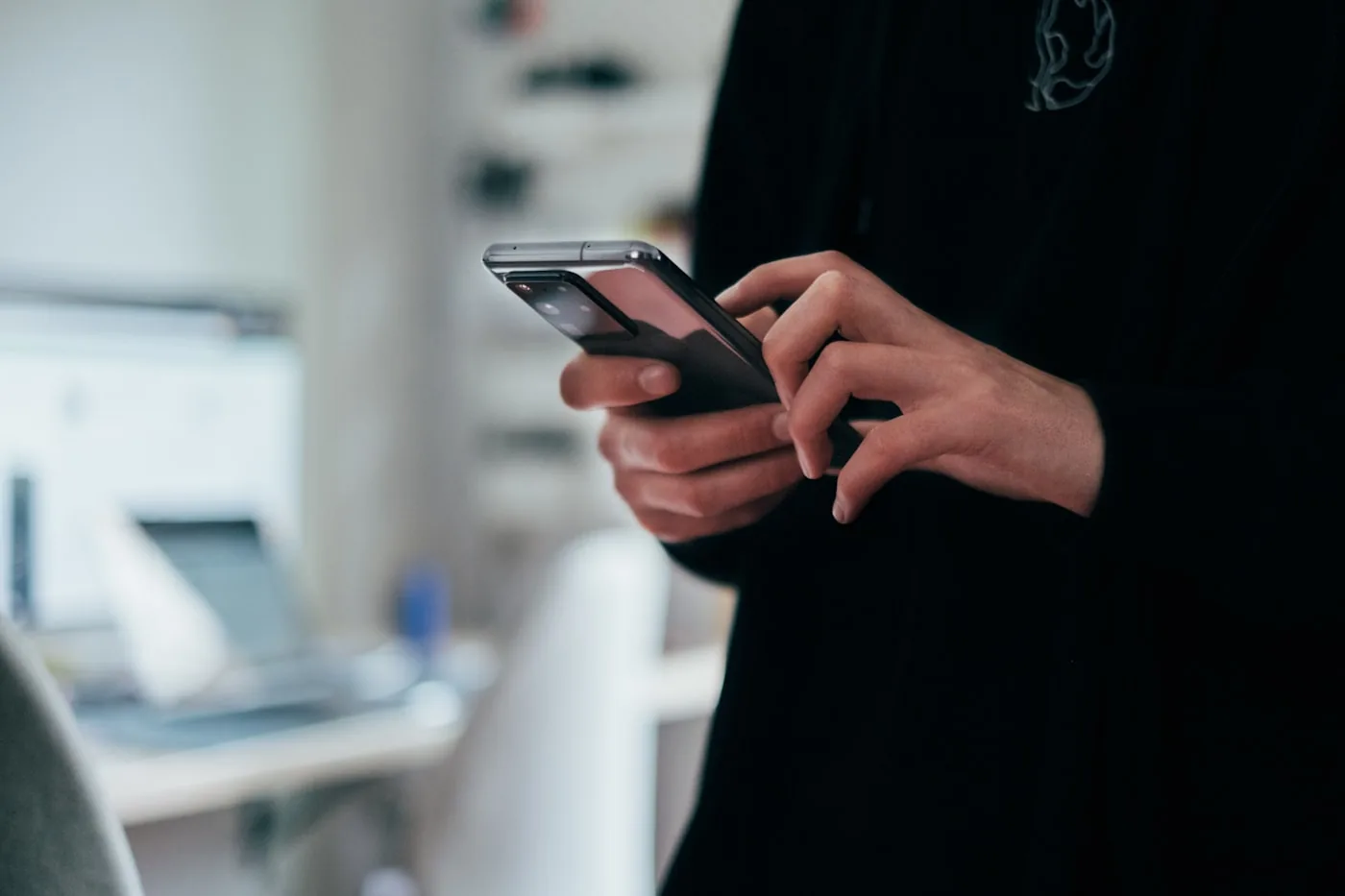 Smartphone mit geöffnetem Chat-Verlauf in einer Hand