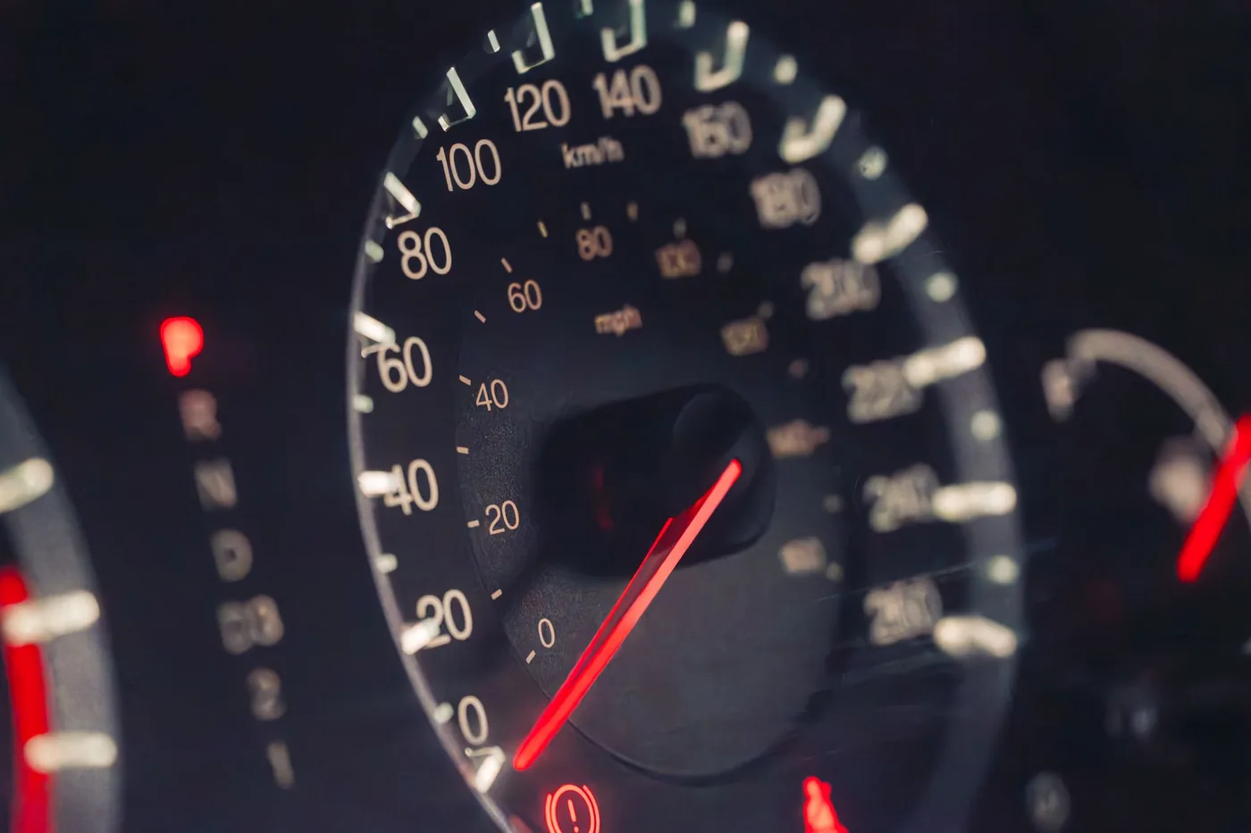 Tachometer mit roter Nadel im Dunkeln