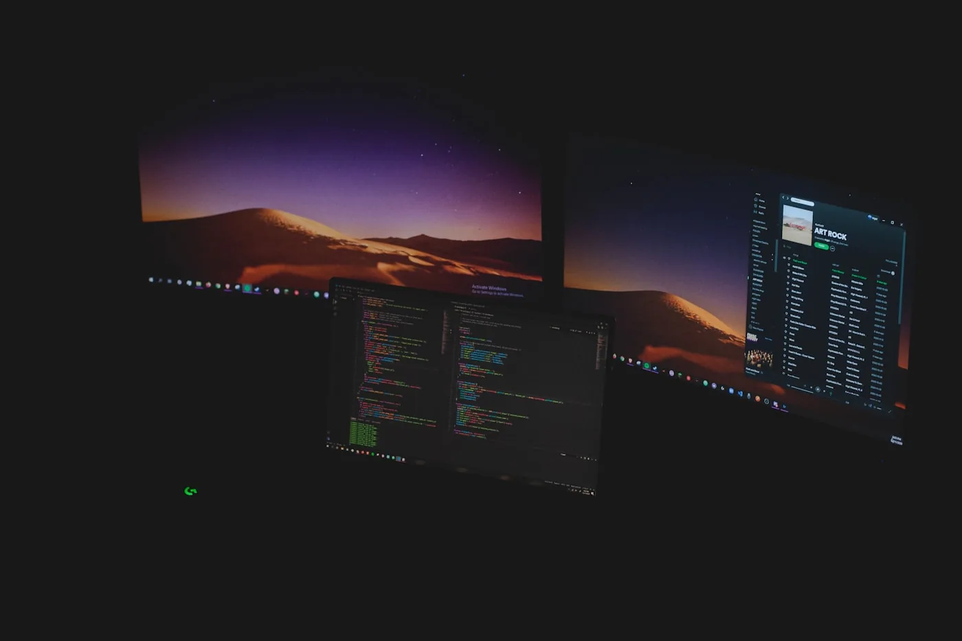 A workspace with several monitors, one showing a code editor