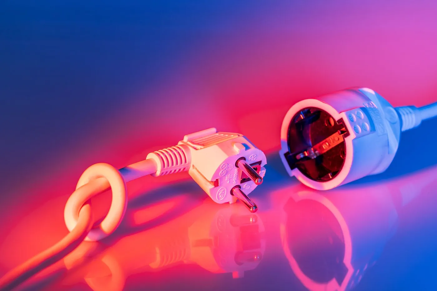 Plug and socket against a red and blue lit background