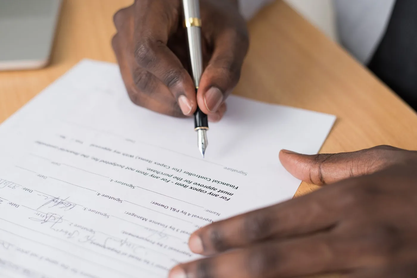 Signing a contract with a pen at a meeting table